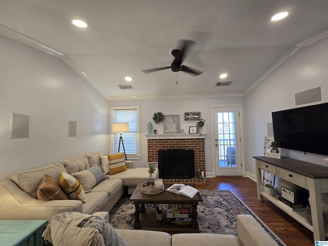 living room with lofted ceiling, ceiling fan, ornamental molding, a fireplace, and dark hardwood / wood-style flooring