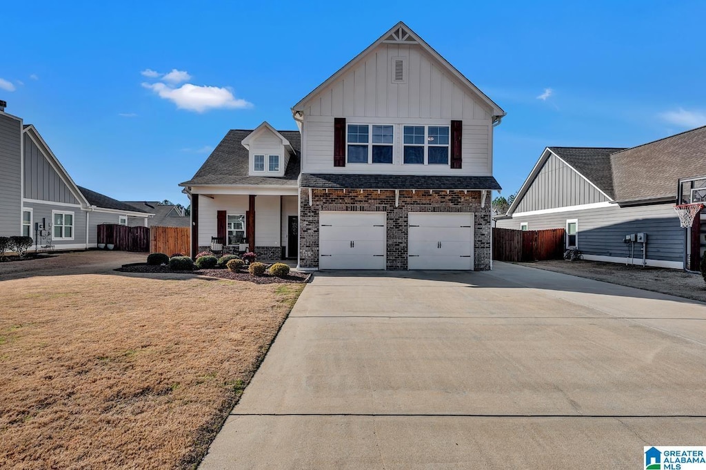 view of front of home with a porch, a front yard, and a garage