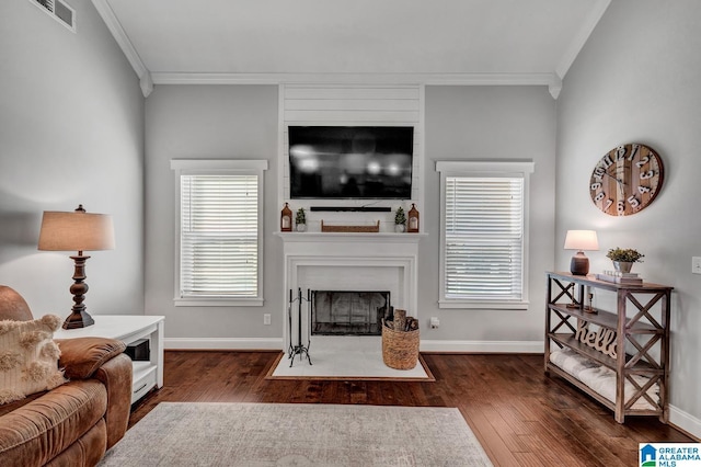 living room with a wealth of natural light, crown molding, and dark wood-type flooring