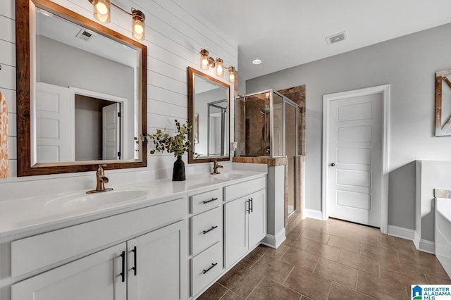 bathroom featuring plus walk in shower, vanity, and tile patterned flooring