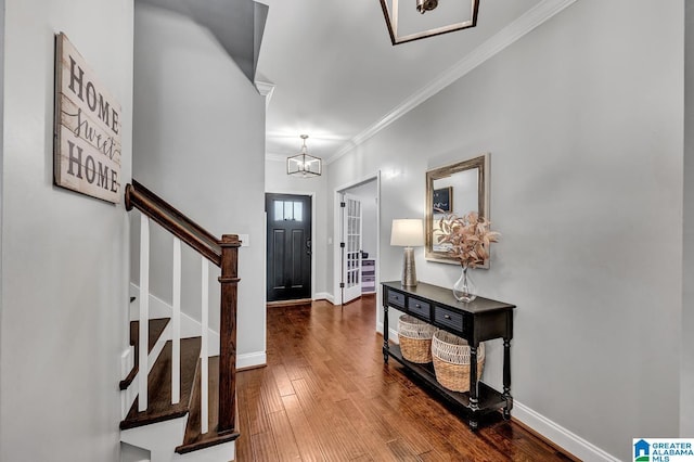 entrance foyer featuring dark hardwood / wood-style flooring, a chandelier, and ornamental molding