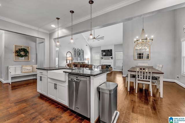 kitchen with stainless steel dishwasher, sink, white cabinetry, and an island with sink