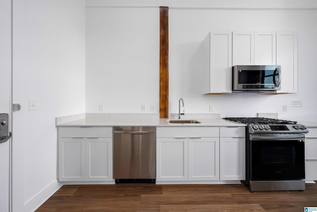 kitchen with dark hardwood / wood-style floors, sink, white cabinetry, and stainless steel appliances