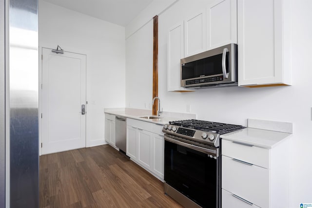 kitchen featuring appliances with stainless steel finishes, dark hardwood / wood-style floors, white cabinetry, and sink