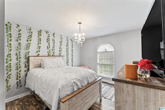 bedroom with dark hardwood / wood-style flooring and an inviting chandelier