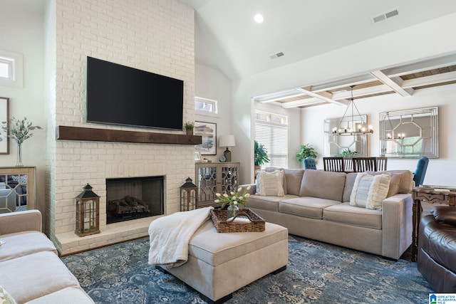 living room with beam ceiling, a chandelier, coffered ceiling, and a brick fireplace