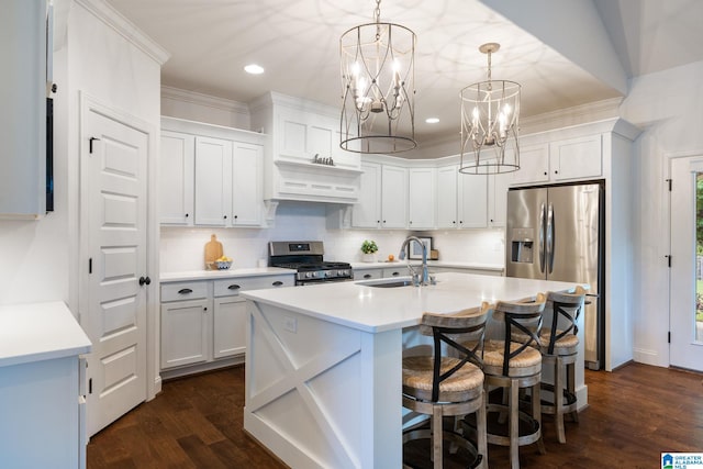 kitchen featuring an inviting chandelier, hanging light fixtures, sink, appliances with stainless steel finishes, and white cabinetry