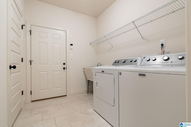 clothes washing area with light tile patterned floors and washer and clothes dryer