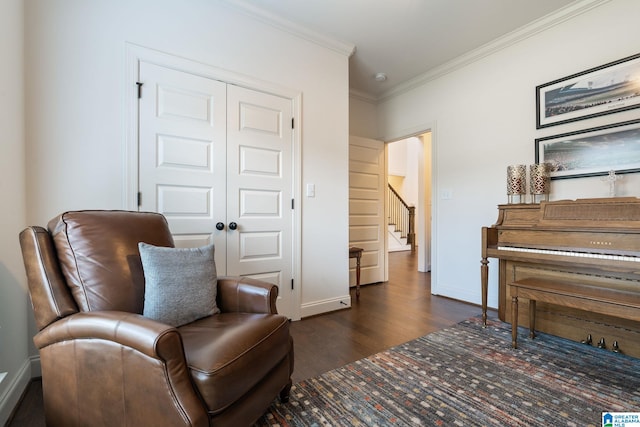 sitting room with ornamental molding and dark wood-type flooring