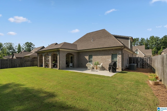 back of property with cooling unit, a patio area, and a yard