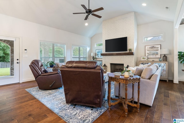 living room with ceiling fan, dark hardwood / wood-style flooring, vaulted ceiling, and a brick fireplace