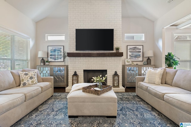 living room featuring dark hardwood / wood-style flooring, a brick fireplace, and lofted ceiling