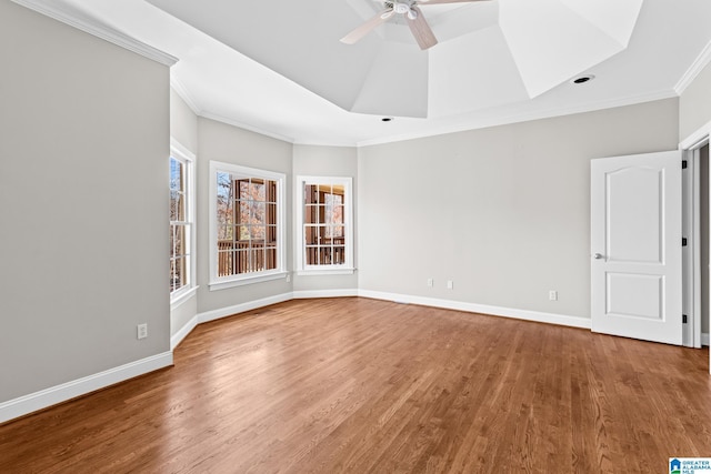 spare room featuring ceiling fan, wood-type flooring, ornamental molding, and a tray ceiling