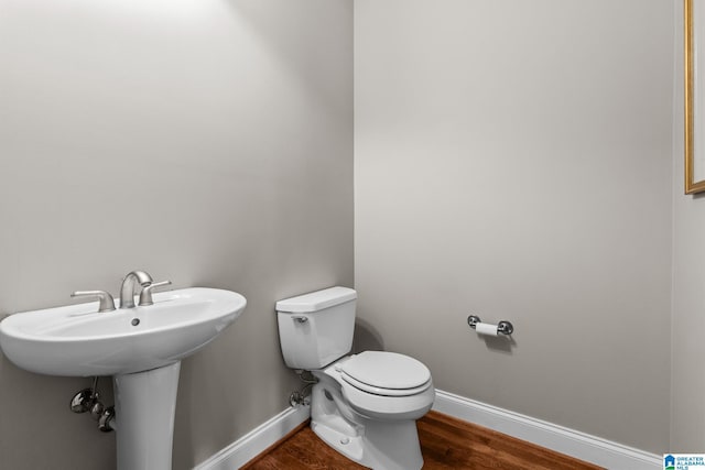 bathroom featuring wood-type flooring and toilet