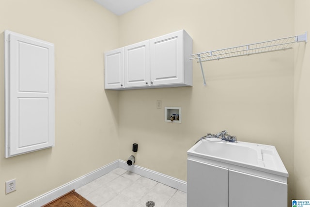 clothes washing area featuring hookup for a washing machine, cabinets, and sink