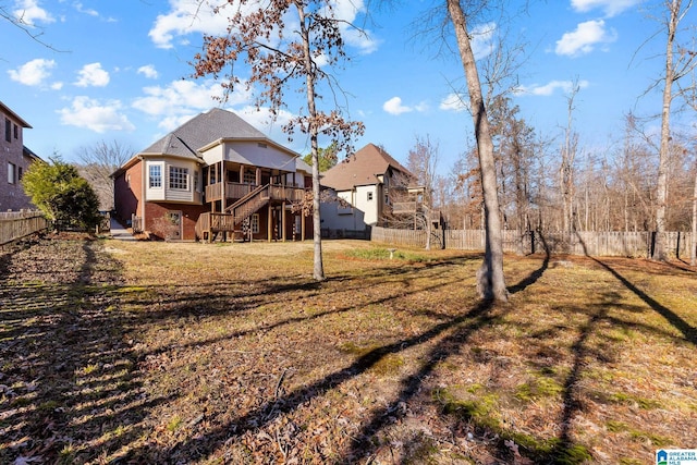 back of house with a deck and a lawn