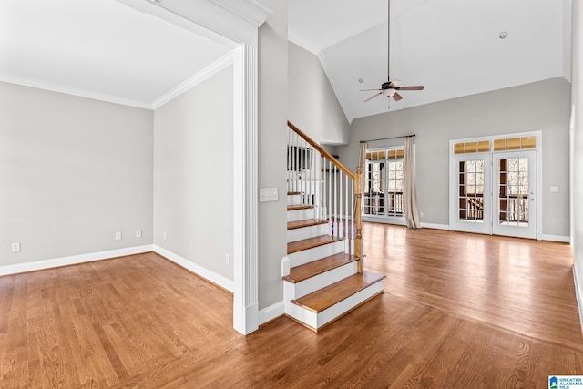 stairs featuring high vaulted ceiling, french doors, crown molding, hardwood / wood-style flooring, and ceiling fan