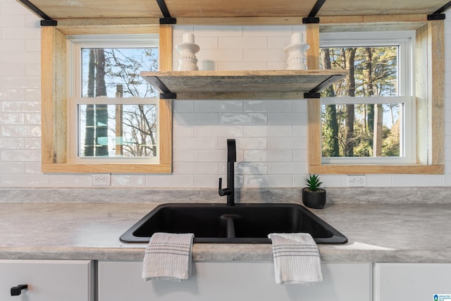 kitchen featuring backsplash, a healthy amount of sunlight, and sink