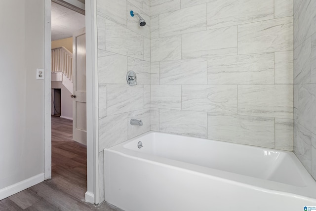 bathroom featuring hardwood / wood-style floors and tiled shower / bath combo