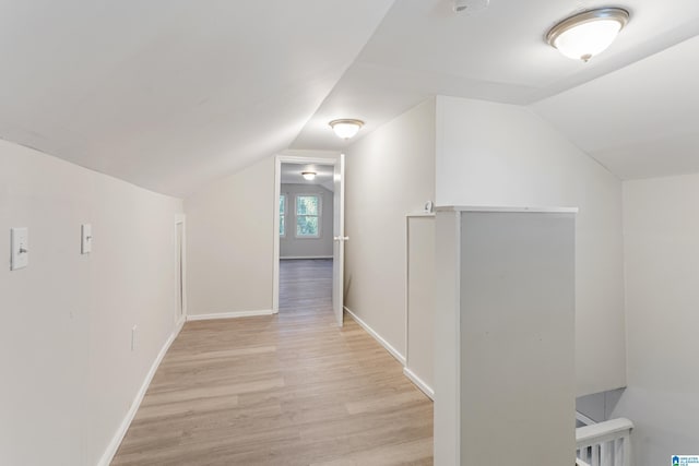 corridor with lofted ceiling and light wood-type flooring