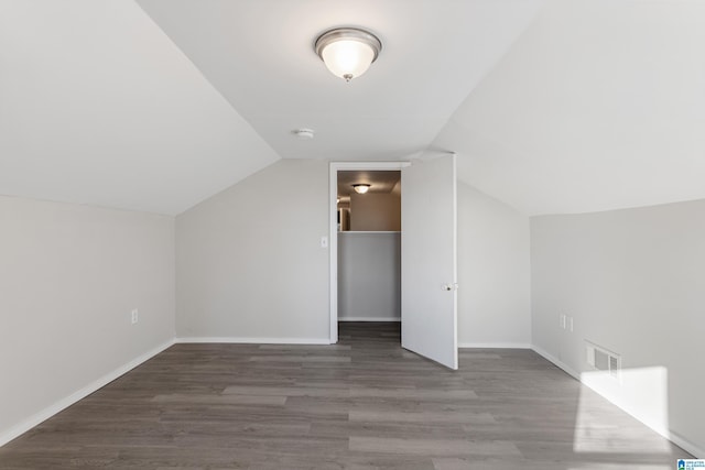 bonus room with dark wood-type flooring and lofted ceiling