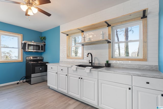 kitchen with sink, ceiling fan, decorative backsplash, appliances with stainless steel finishes, and white cabinetry