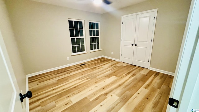 unfurnished bedroom with hardwood / wood-style flooring and a closet