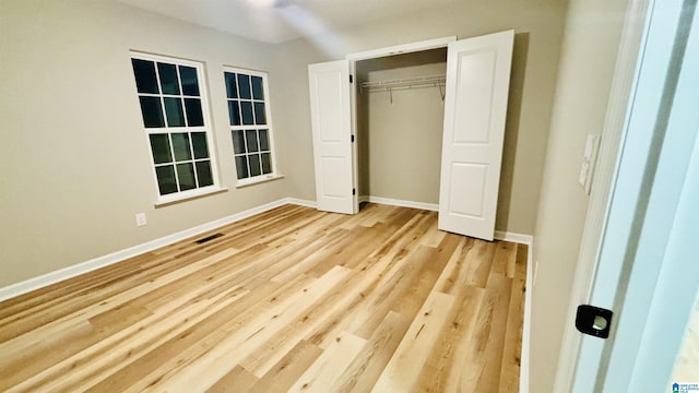 unfurnished bedroom featuring light wood-type flooring and a closet