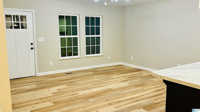 unfurnished dining area with an inviting chandelier and light hardwood / wood-style flooring