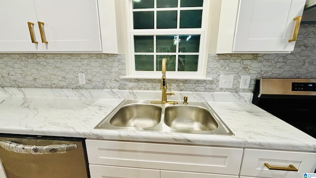 kitchen with white cabinets, stainless steel dishwasher, and sink