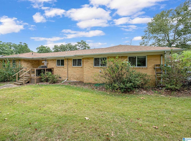 rear view of property featuring a yard and a deck