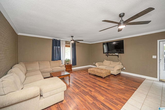 living room with hardwood / wood-style floors, ceiling fan, ornamental molding, a textured ceiling, and brick wall