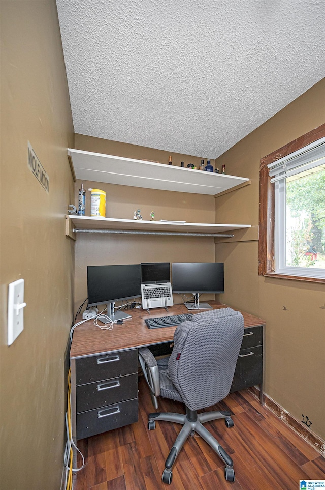 home office with dark hardwood / wood-style flooring and a textured ceiling