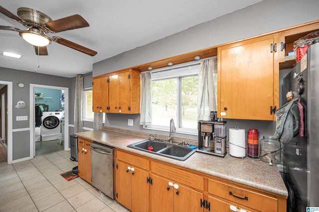 kitchen with stainless steel dishwasher, ceiling fan, sink, and washing machine and clothes dryer