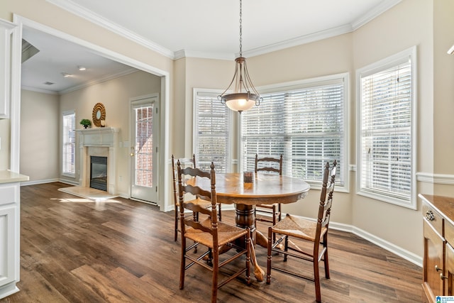 dining space featuring ornamental molding, dark hardwood / wood-style floors, and a fireplace