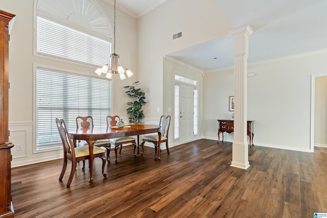 dining room with ornamental molding, dark hardwood / wood-style flooring, an inviting chandelier, and decorative columns