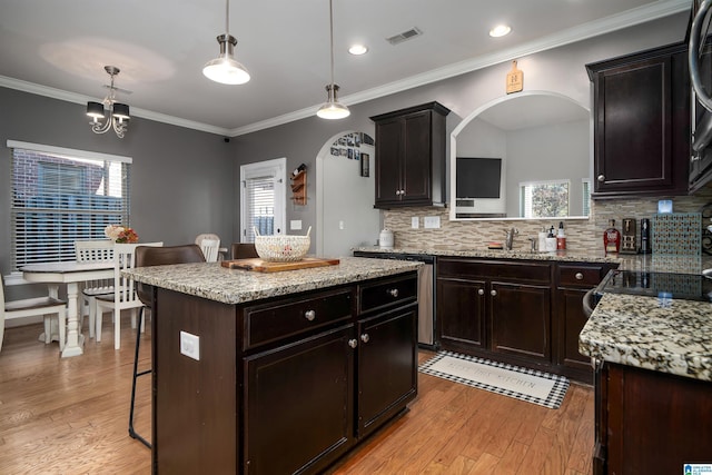 kitchen featuring decorative backsplash, a kitchen breakfast bar, a center island, and hanging light fixtures