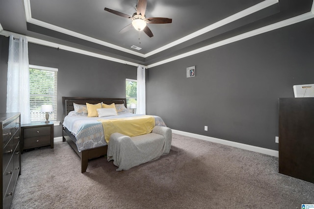 carpeted bedroom featuring ceiling fan, a raised ceiling, and crown molding