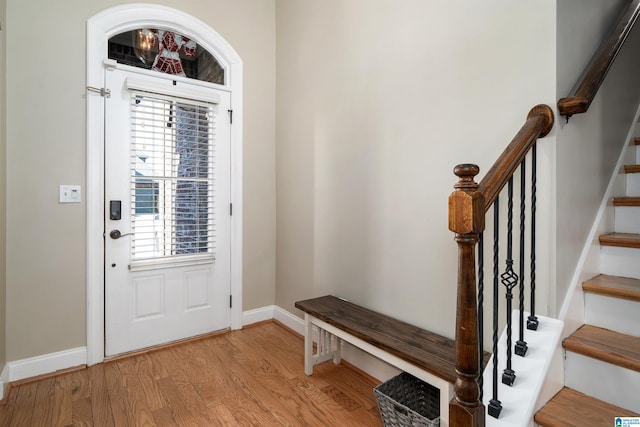 interior space with light wood finished floors, baseboards, and stairway
