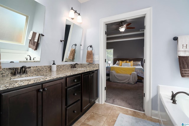 bathroom featuring tile patterned flooring, vanity, ceiling fan, and a bathing tub