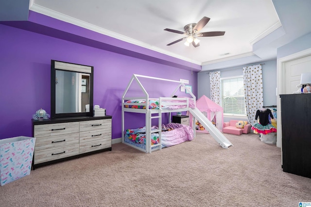 carpeted bedroom with ceiling fan, a raised ceiling, and ornamental molding