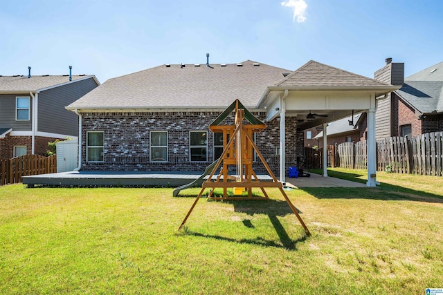 view of jungle gym featuring a lawn, ceiling fan, a storage unit, and a patio area