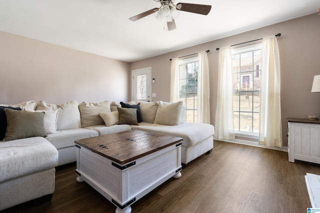 living room featuring dark wood-type flooring and ceiling fan