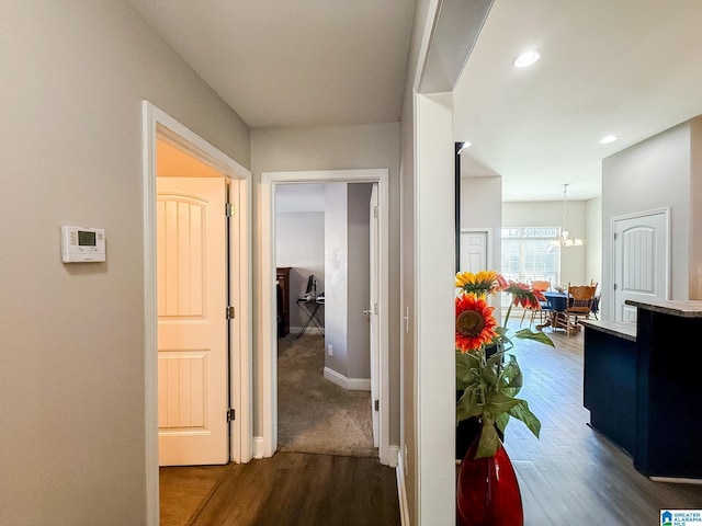 hallway featuring a notable chandelier and dark hardwood / wood-style flooring