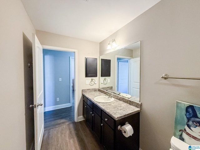 bathroom featuring hardwood / wood-style flooring, vanity, and toilet