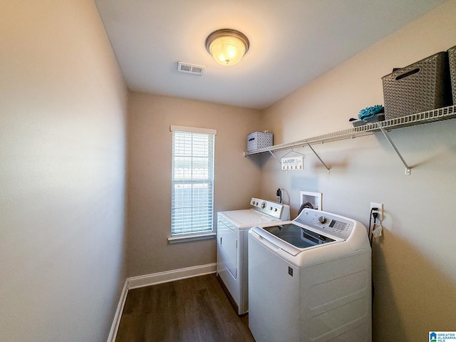 clothes washing area with separate washer and dryer and dark wood-type flooring