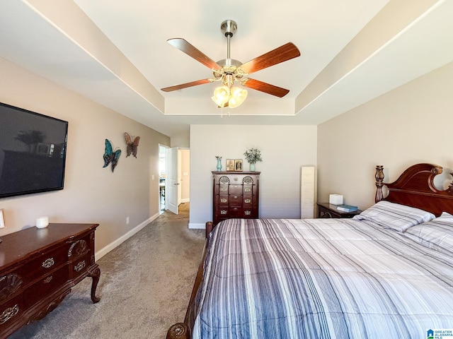 bedroom with a tray ceiling and ceiling fan