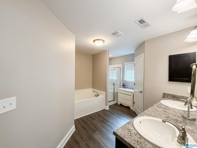 bathroom with hardwood / wood-style floors, vanity, and shower with separate bathtub