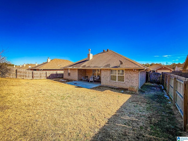 back of property with a lawn and a patio area