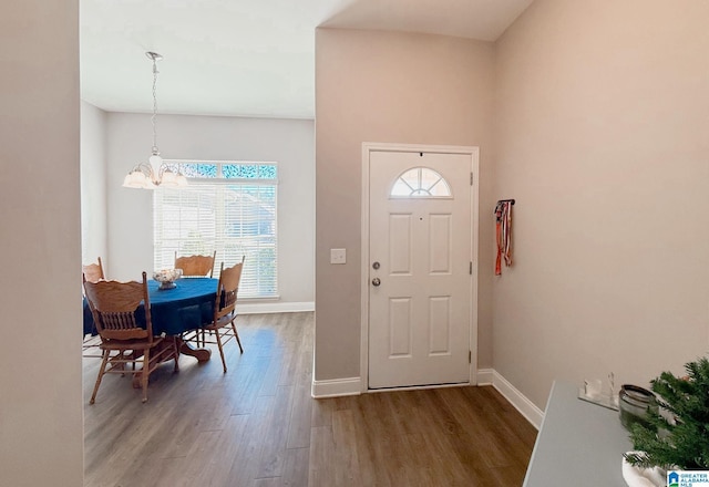 foyer entrance with hardwood / wood-style floors and an inviting chandelier